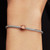 Modelo luciendo el Charm Mini Sol Naranja de Pandora en plata de ley y esmalte naranja en la muñeca - 794818C01