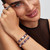 Modelo luciendo múltiples charms de Pandora Moments incluyendo el Charm Mini Pieza de Puzle Morada en plata de ley y esmalte morado - 794816C02