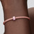 Primer plano de muñeca con modelo luciendo el Charm Mini Cristal de Murano Rosa - 794773C05
