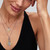 Modelo luciendo varios collares con el Charm Medallón Zodiaco Géminis de Pandora en plata y chapado en oro - 764989C01