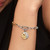 Modelo luciendo el Charm Medallón Zodiaco Acuario de Pandora en plata y chapado en oro colgado de una pulsera - 764990C01