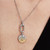 Modelo luciendo el Charm Medallón Zodiaco Escorpio de Pandora en plata y chapado en oro colgado de una cadena - 764985C01