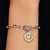 Modelo luciendo el Charm Medallón Zodiaco Piscis de Pandora en plata y chapado en oro en una pulsera - 764991C01