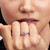 Modelo luciendo el Anillo Pandora Flor de Cerezo Mulán de Disney de plata con circonitas y esmalte rosa en primer plano - 135027C01