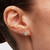 Modelo luciendo los Pendientes de Botón Pandora Estrella Brillante de plata con circonitas transparentes en vista lateral de la oreja - 295089C01