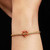 Modelo luciendo el Charm Pandora Bastón de Caramelo Corazón en Filigrana en una pulsera dorada en la muñeca - 765063C01