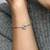 Modelo mostrando Charm Logotipo y Corona de Pandora - 799036C00