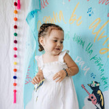 Female Child in white dress standing in front of Blue Coco Moon Hawaii Three little birds swaddle