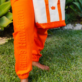 Lifestyle image of King's Hawaiian orange joggers with embossed logo down the leg, front Lifestyle image of King's Hawaiian orange joggers with embossed logo down the leg, front