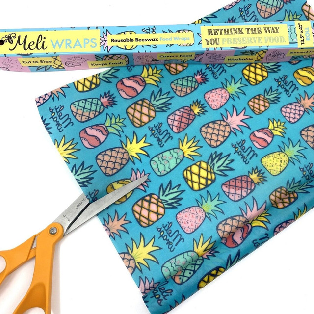 Image of Organic Cotton Beeswax Food wrap Bulk Roll with Multi colored pineapple pattern on blue background with scissors and bulk roll box