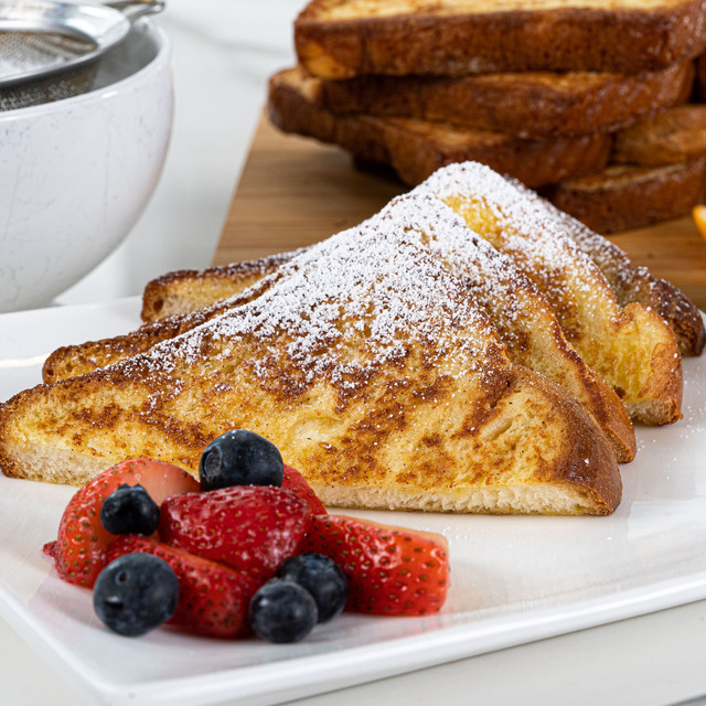 Delectable slices of french toast made with King's Hawaiian French Toast Batter Mix 8oz and King's Hawaiian Original Hawaiian Sweet Sliced Bread 12oz, dusted with powdered sugar