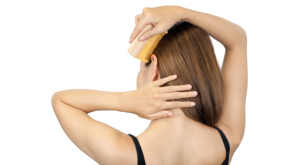 Japanese woman combing her hair with a tsuge wood comb, illustrating traditional hair care routine 