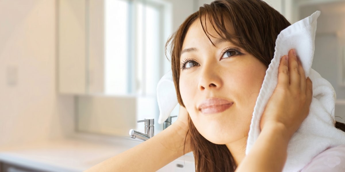 Japanese woman gently touching her hair as part of a natural hair care routine
