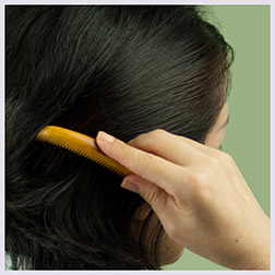 Japanese woman combing hair with traditional 'Tokigushi' tsuge wood comb