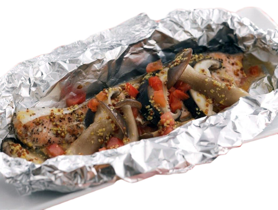 salmon with mushrooms and garnish placed on foil ready to bake