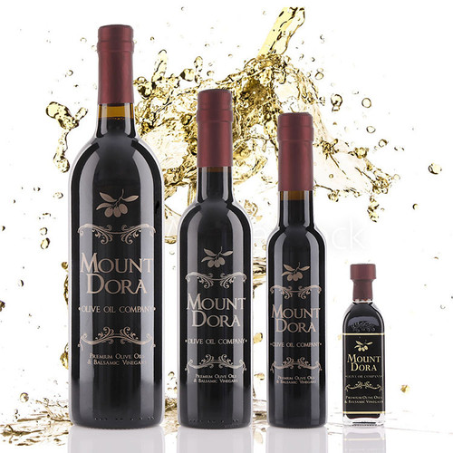 Four different size bottles of Mount Dora Olive Oil Company Champagne Dark Balsamic Vinegar.