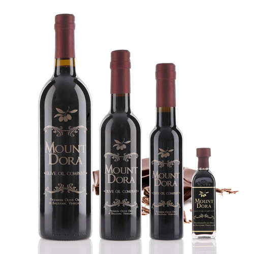 Four different size bottles of Mount Dora Olive Oil Company Dark Chocolate Dark Balsamic Vinegar