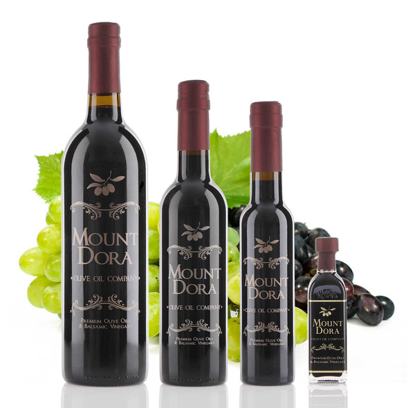 Four different size bottles of Mount Dora Olive Oil Company 18 year Traditional Dark Balsamic Vinegar