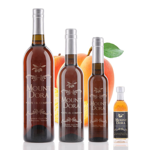 Four different size bottles of Mount Dora Olive Oil Company Blenheim Apricot White Balsamic Vinegar.