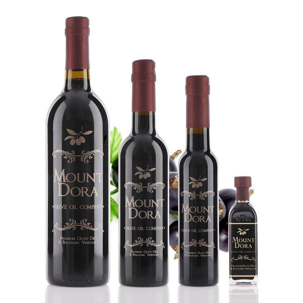 Four different size bottles of Mount Dora Olive Oil Company Black Currant Dark Balsamic Vinegar