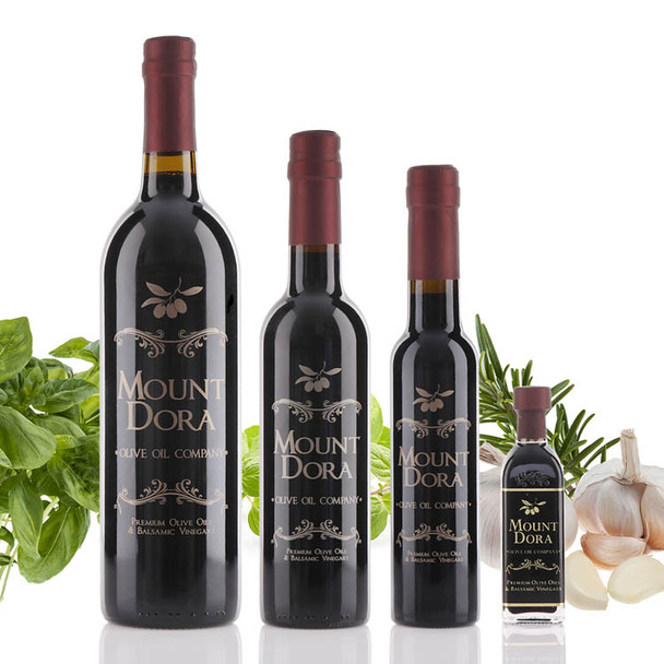 Four different size bottles of Mount Dora Olive Oil Company's Neapolitan Herb Dark Balsamic Vinegar.