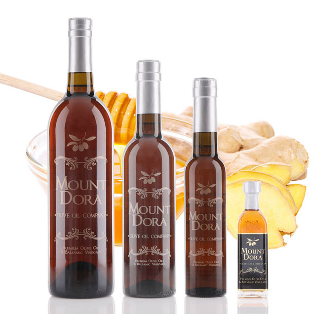 Four different size bottles of Mount Dora Olive Oil Company Honey Ginger White Balsamic Vinegar