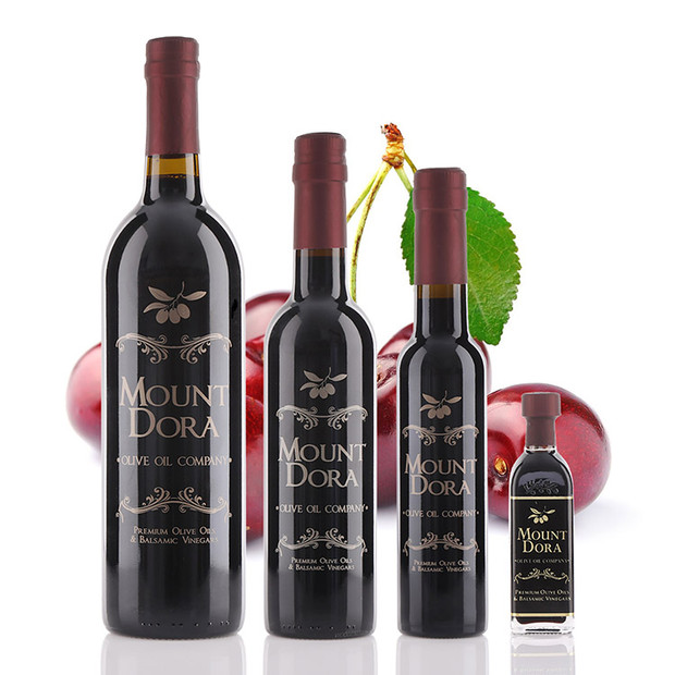 Four different size bottles of Mount Dora Olive Oil Company Black Cherry Dark Balsamic Vinegar.