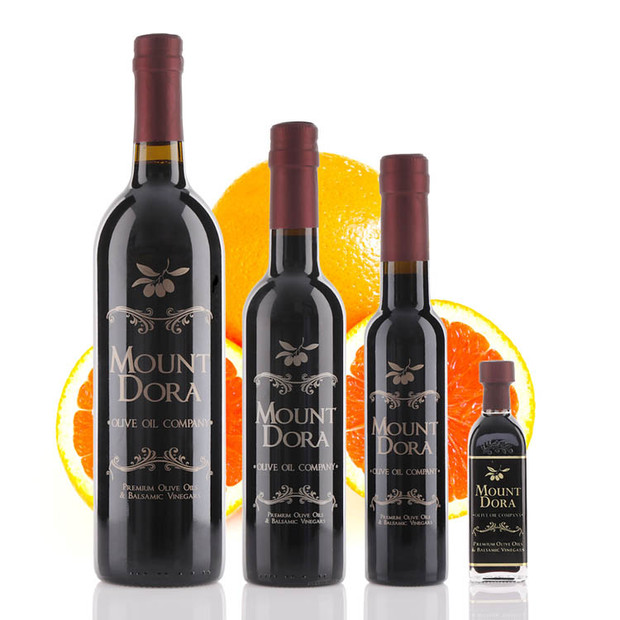 Four different size bottles of Mount Dora Olive Oil Company Tangerine Dark Balsamic Vinegar.