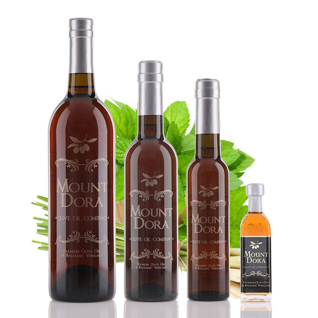 Four different size bottles of Mount Dora Olive Oil Company Lemongrass Mint White Balsamic Vinegar