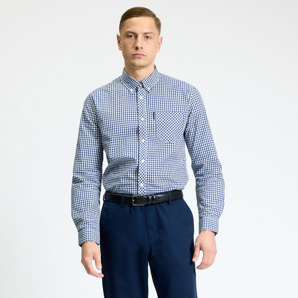 Man wearing Ben Sherman Mens Signature Gingham Button Down Long Sleeve Shirt in Dark Blue tucked in