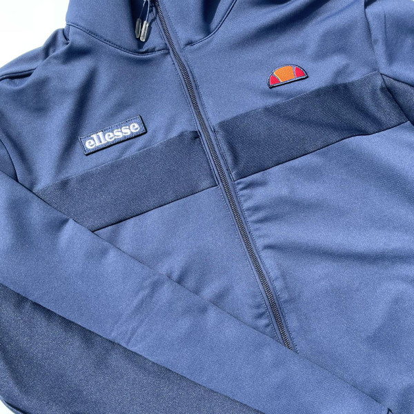 Close up on chest contrast on Ellesse mens Riminali Live Forever 90s zip track top navy