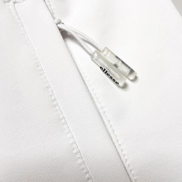 Close up on pocket zip on Ellesse mens Riminali Live Forever 90s zip track top in white