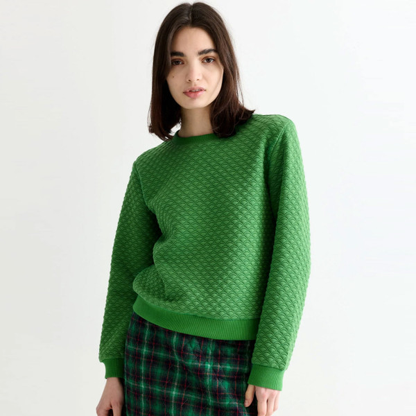 Woman wears Louche London Jan Scallop Quilted Womens Sweatshirt in Green 60085
