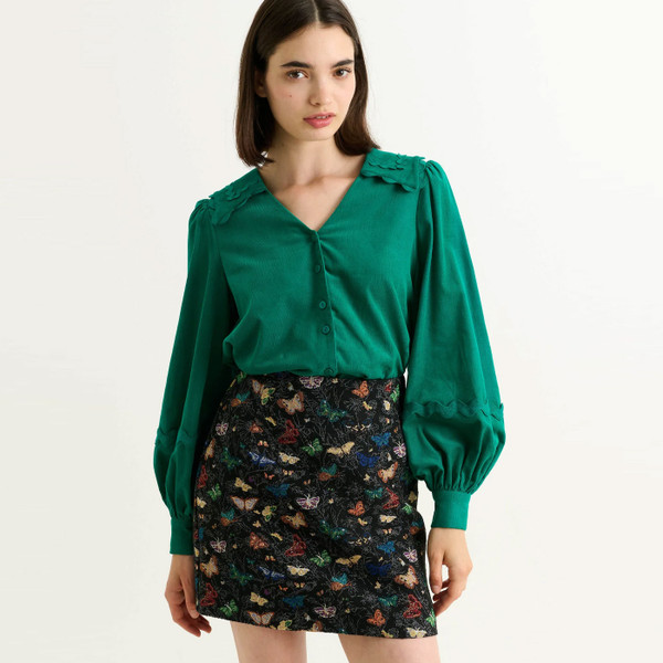 Woman wears Louche London Aubin Butterfly Ball Mini A-Line Skirt in Black 60018