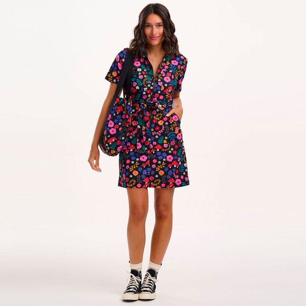 Woman wearing Sugarhill Brighton Tasha Toadstool & Floral Print Mini Dress in Navy D1395 and holding matching bag