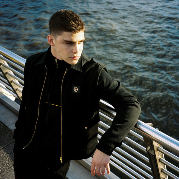 Man wears Sergio Tacchini New Tomasso Retro Collared Jacket in Black