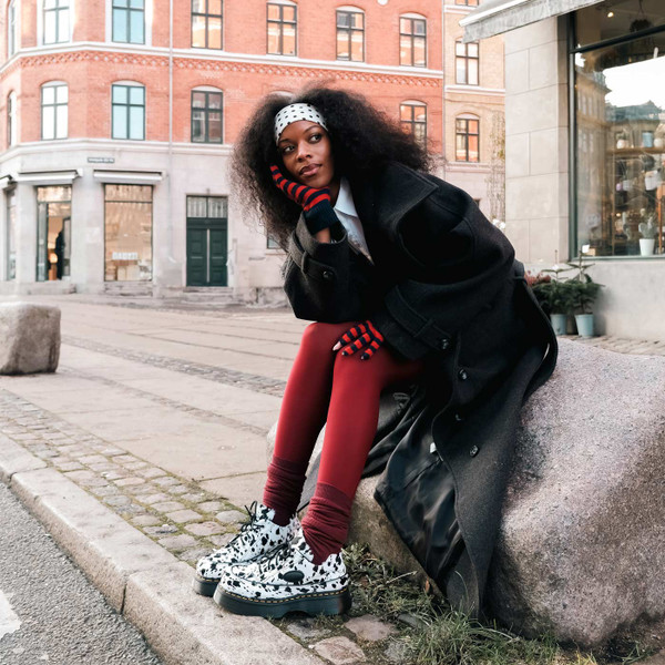 Model Wearing Dr Martens Buzz Dalmatian Hair On 5 Eyes Platform Shoes - Sitting on Rock