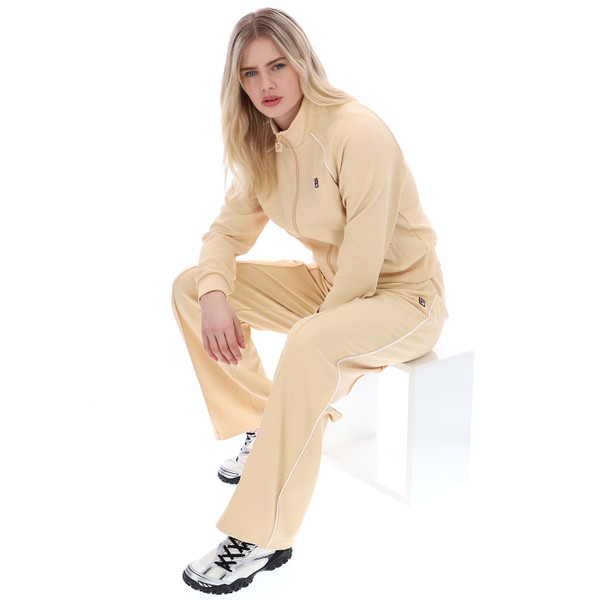 Woman sitting wearing Fila Vintage Marina Women’s Wide-Leg Relaxed Track Pants in Beige