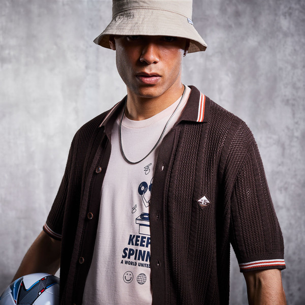 Lifestyle football photo of man wearing Ben Sherman Textured Tipped Knitted Button Through Polo Shirt in Coffee