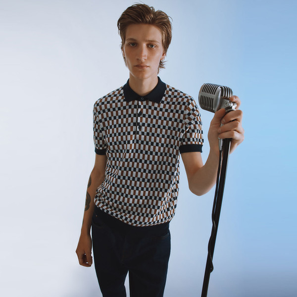 Rock lifestyle photo of man wearing Ben Sherman Mod Ska Jacquard Chequerboard Knit Polo Shirt in Dark Navy