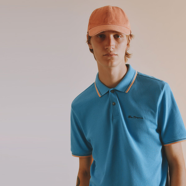 Lifestyle photo of man wearing Ben Sherman Men's Retro Tipped Signature Pique Polo Shirt in Lake Blue