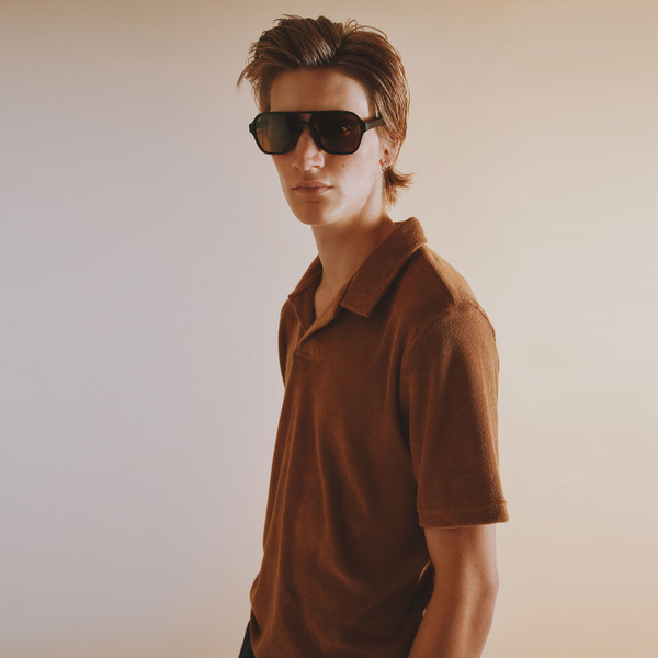 Lifestyle photo of man wearing Ben Sherman Brighton Beach Club Retro 70s Towelling Polo Shirt in Light Brown