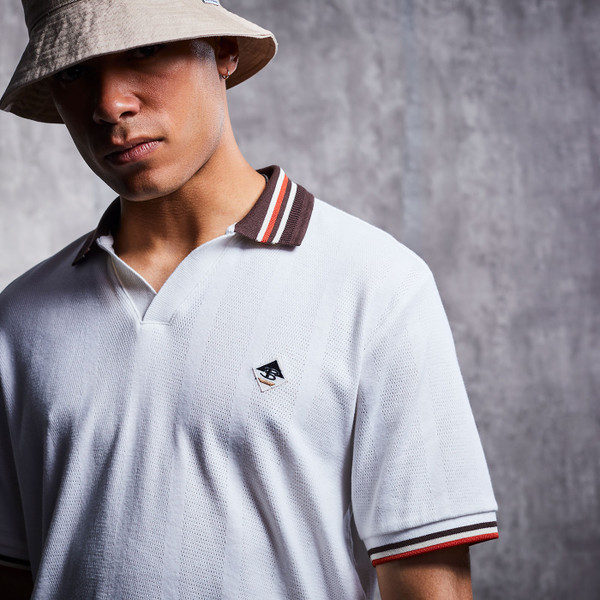 Lifestyle photo of man wearing Ben Sherman Men's Retro Textured Contrast Collar Skipper Neck Polo Shirt in Snow White