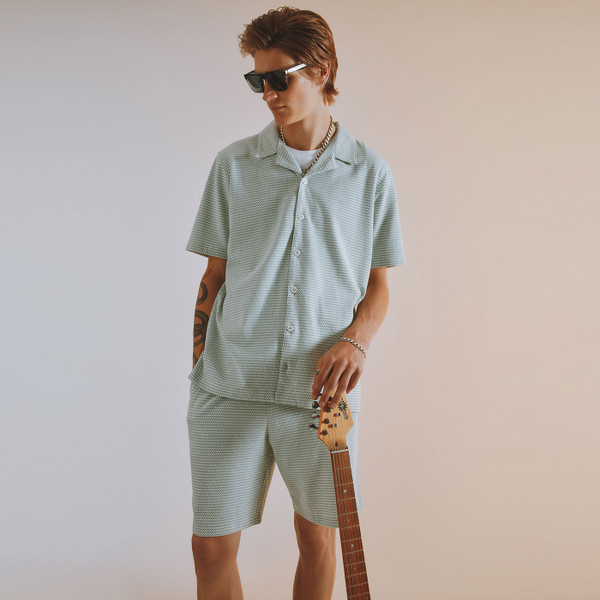 Man wearing Ben Sherman Men's Retro 70s Textured Shorts in Mint Green with matching shirt