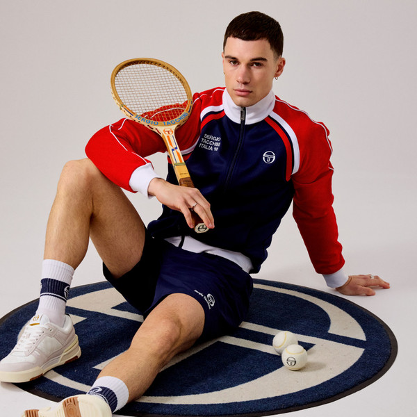 Lifestyle tennis shot of Sergio Tacchini Ghibli Davis Retro 60s McEnroe Track Top in Maritime Navy & Red