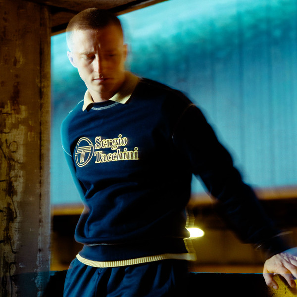 Man wearing Sergio Tacchini Mens Cameri Logo Crew Neck Sweatshirt in Maritime Blue