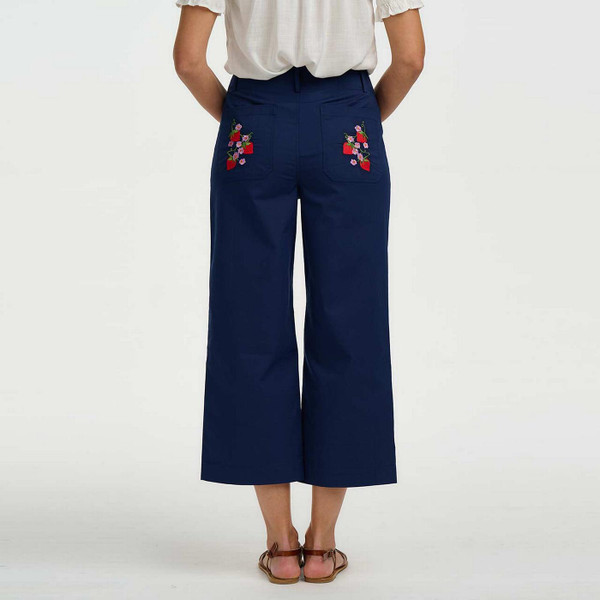 Model Wearing Sugarhill Brighton Skye Women's Retro 70s Wild Strawberry Embroidered Trousers in Navy - Back View