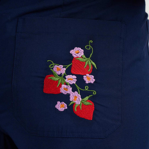 Model Wearing Sugarhill Brighton Skye Women's Retro 70s Wild Strawberry Embroidered Trousers in Navy - Embroidery Detail