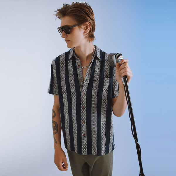 Lifestyle photo of man wearing Ben Sherman Men's Retro Block Geo Jacquard Stripe Short Sleeve  Shirt in Twilight Denim