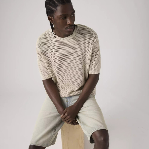Model Sitting Down Wearing the Levi's Stinson Chainmaille Open Gauge Knit Textured Men's Retro T-shirt in Pumice Stone